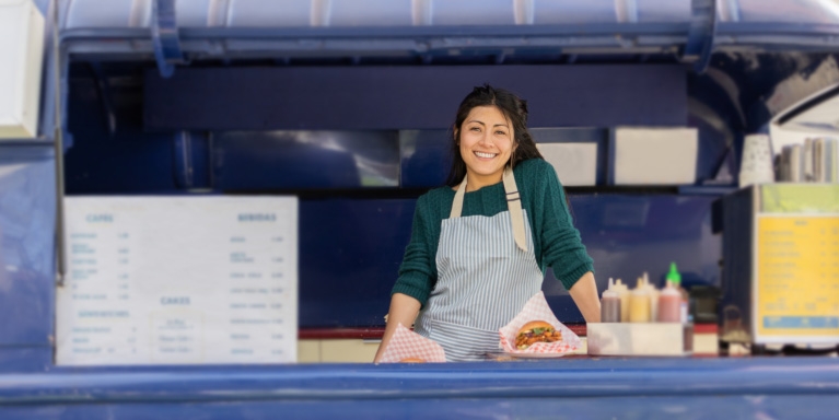 Business owner serving customers from a mobile food business.