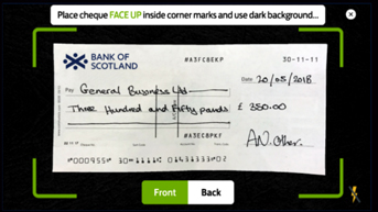 Lay the cheque on a flat surface with a dark background.
