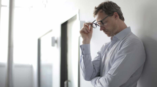 Man taking off glasses looking stressed